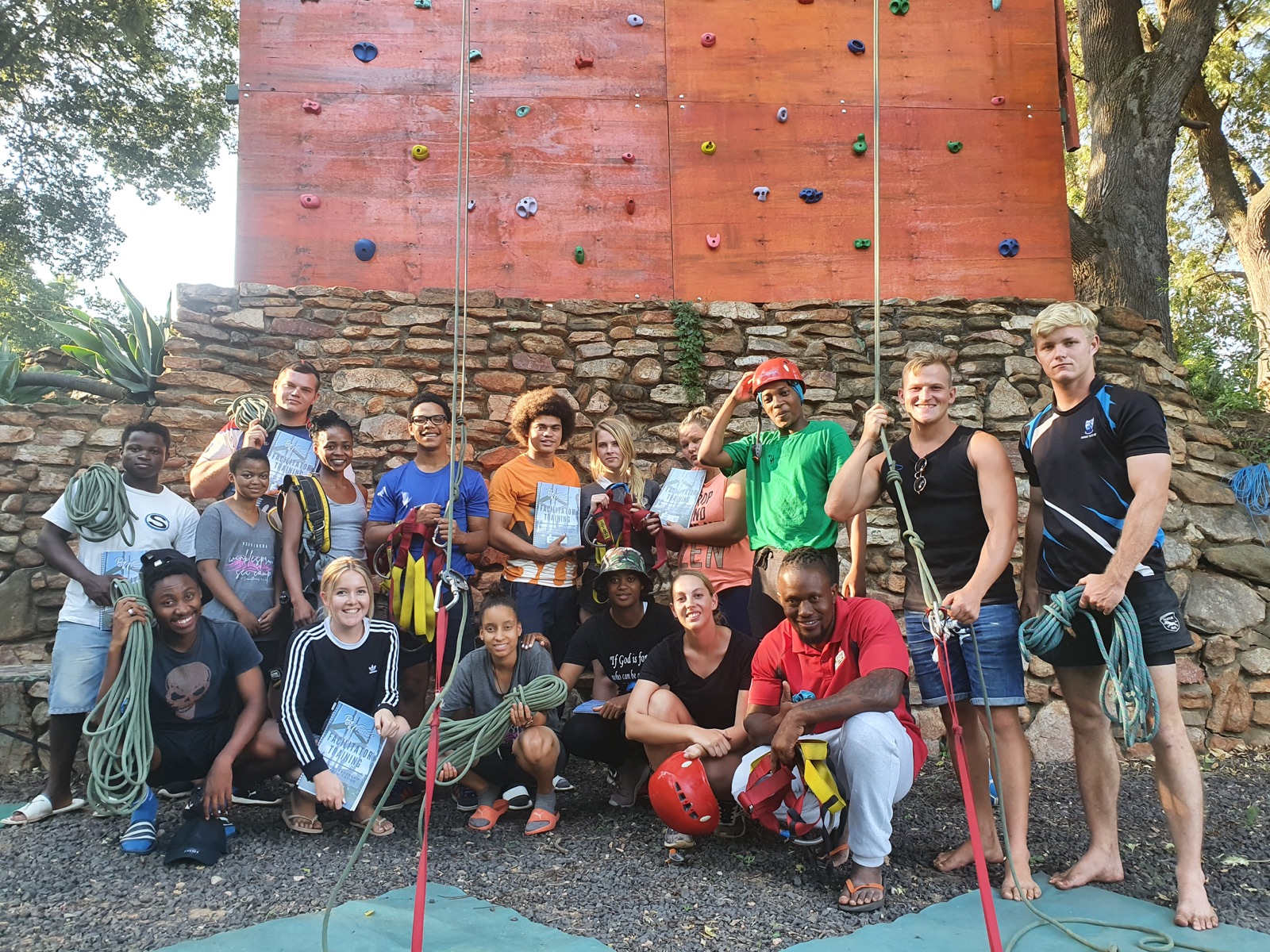 A facilitator group gathered with technical climbing equipment