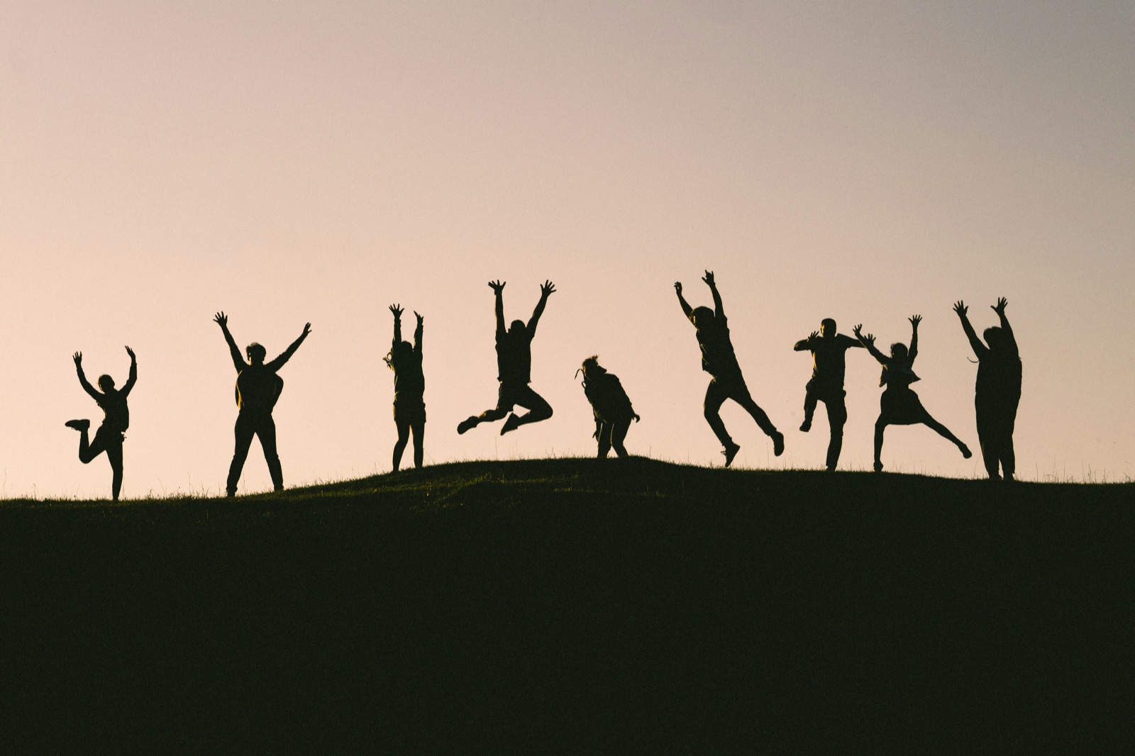 A group of participants jumping together outdoors
