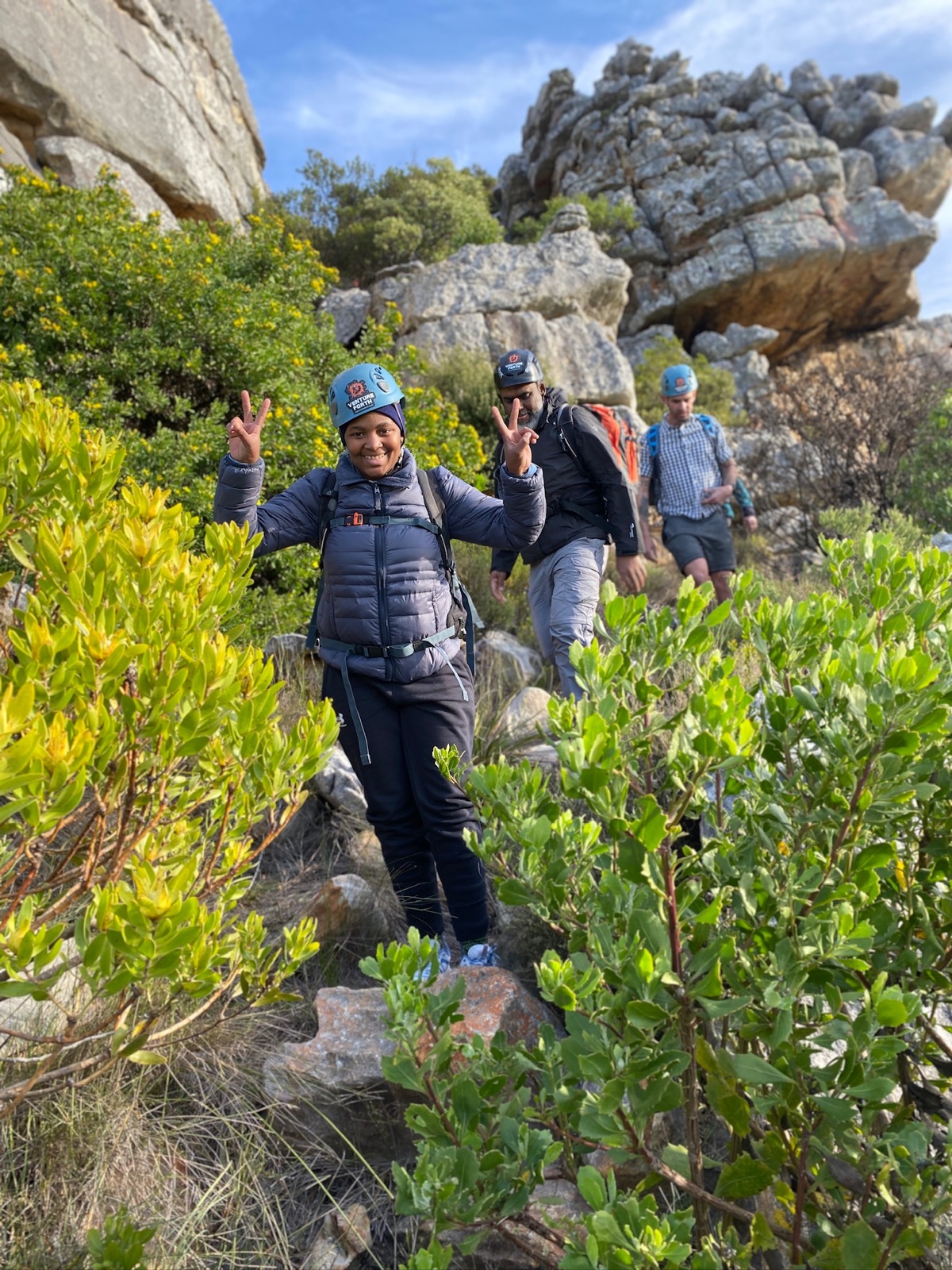 A woman leading a group through mountain terrain