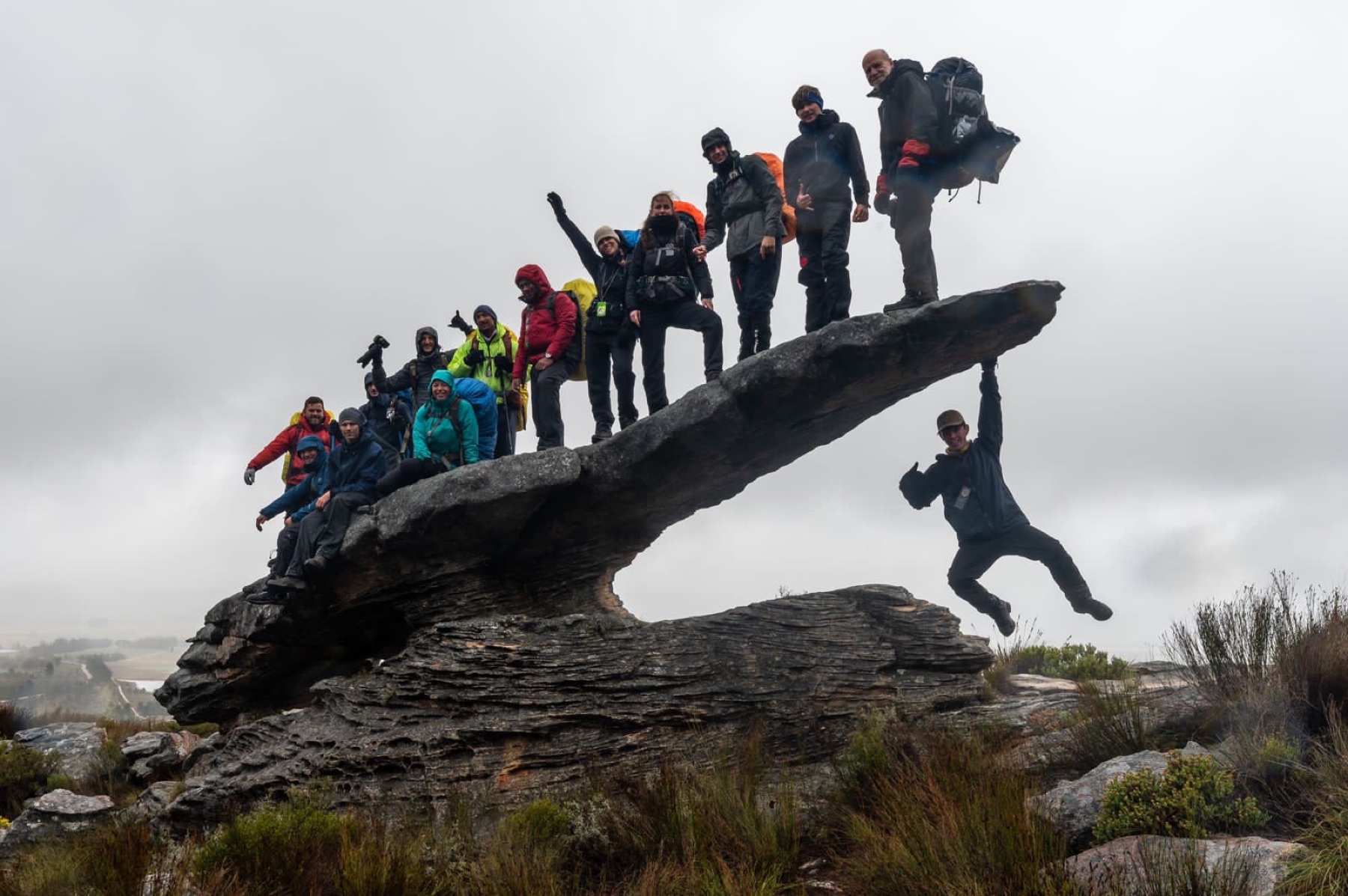 An outdoor programme team gathered on a mountain outcrop
