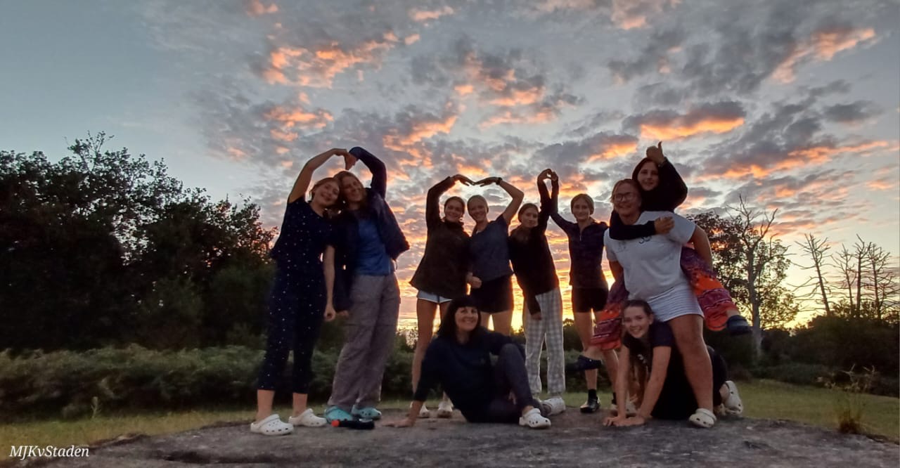 A group of young people gathered together at sunset